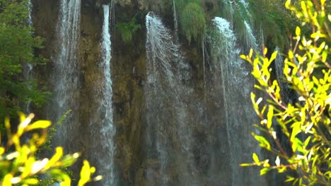 Hohe,-Dünne-Wasserfälle-Mit-Leuchtend-Grünen-Büschen-Im-Vordergrund-Im-Nationalpark-Plitvicer-Seen-In-Kroatien,-Europa-Mit-¼-Geschwindigkeit