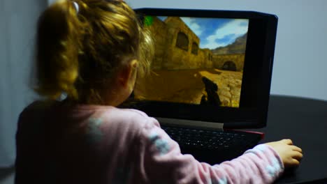Kleines-Mädchen,-Das-Allein-Auf-Dem-Laptop-Das-Unangemessene-Computerspiel-Counter-Strike-Spielt