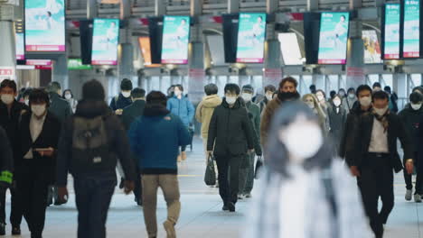 Menschenmenge,-Die-Wegen-Einer-Pandemie-In-Tokio,-Japan,-Mit-Maske-Am-Bahnhof-Shinagawa-Läuft