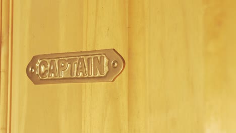 Brass-metal-Captain-sing-mounted-on-wooden-door