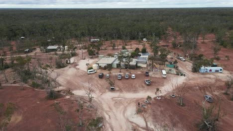 High-aerial-view-of-a-car-arriving-at-a-old-opal-mining-pub-in-the-Australian-outback