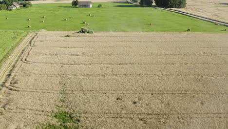 Farmers-using-combine-harvesters-to-harvest-rye-grain-crop,-aerial-view