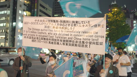Activistas-Sosteniendo-Pancartas-Con-Mensajes-Para-Liberar-A-Los-Uigures-Detenidos-Por-Las-Autoridades-Chinas-En-Turkestán-Oriental-Y-China---Protesta-Conjunta-En-Tokio,-Japón---Primer-Plano