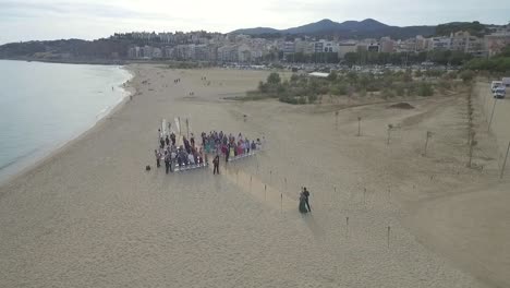 Couple-Walking-Down-the-Aisle-at-Beach-Wedding-Ceremony,-Aerial-Circling