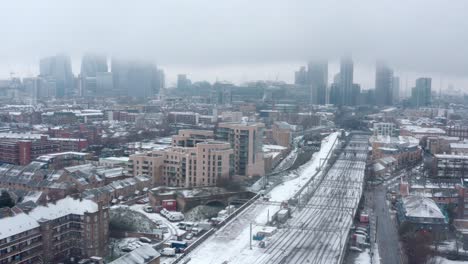 Dolly-back-aerial-drone-shot-of-Snow-covering-Central-London-and-train-tracks
