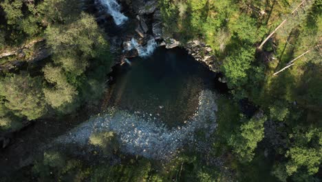 Aerial-top-down-view-people-bathing-at-Waterfall-surrounded-by-Nature