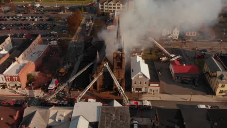 Multiple-fire-departments-arriving-to-scene-of-burning-church,-Aerial
