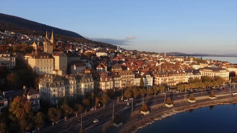 Aerial-view-of-the-city-of-Neuchâtel-in-Switzerland,-sunset-on-a-fall-day,-castle-of-Neuchâtel