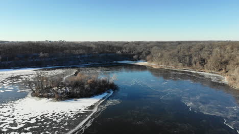 Drone-video-flying-over-a-partially-frozen-lake-in-the-middle-of-winter
