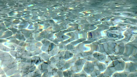 Sonnenlicht-Erzeugt-Abstrakte-Muster-Auf-Der-Reflektierenden-Oberfläche-Eines-Schwimmbades---Hintergrundtextur