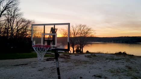 Spalding-Basketballkorb-Im-Freien-Mit-Wunderschönem-Sonnenuntergang-Am-See-Im-Hintergrund