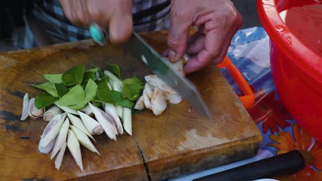 Woman-using-a-dull-knife-to-cut-vegetables-on-a-wooden-cutting-board