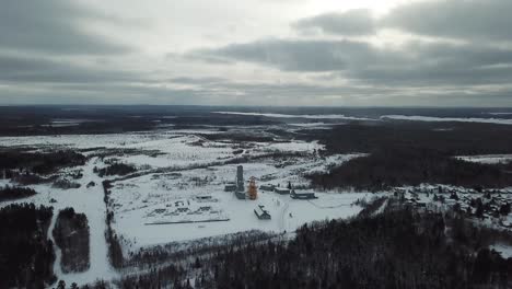 Öl--Und-Goldmine-Im-Winterlichen-Kanada-Mitten-Im-Wald---Drohnen-4K-Luftaufnahme
