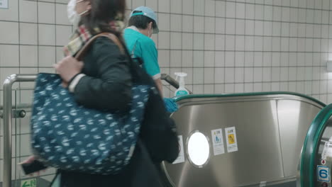 Cleaner-Sanitizing-Escalator-Handrail-Inside-A-Building-In-Tokyo---Coronavirus-Pandemic---medium-shot,-slow-motion