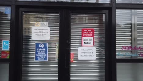 A-close-up-of-covid-signs-on-a-shop-shutter-during-the-Tier-4-lockdown-in-Scotland