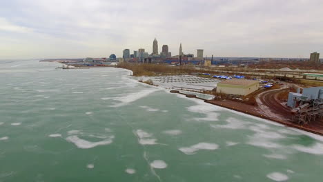 Wide-revealing-drone-shot-of-downtown-Cleveland-Ohio-and-a-frozen-Lake-Erie
