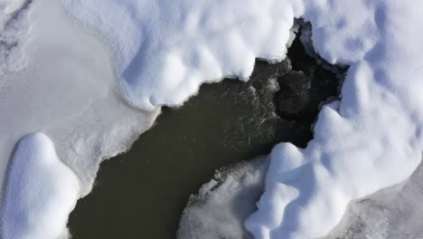 stream-rushing-water-keep-winter-ice-and-snow-melted-overhead-view