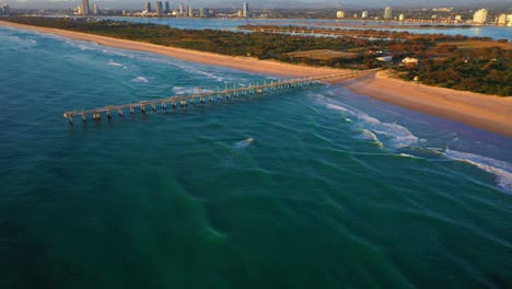 Drone-flying-over-gold-Coast-seaway-and-Jetty,-sunrise,surf,-peaceful