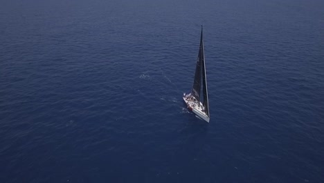 Aerial-view-of-sailboat-sailing-in-open-blue-ocean-waters