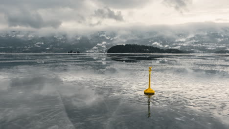 Calm-Icy-Steinsfjorden-In-Vik,-Norway-With-Yellow-Lake-Buoy-And-Reflections-Of-Clouds-Soaring-Above