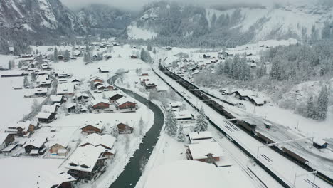 Aerial-of-cargo-train-parked-in-snow-covered-small-town