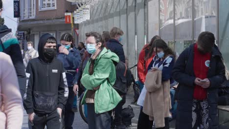 Close-up-of-young-males-and-females-people-in-medical-masks-standing-at-bus-stop