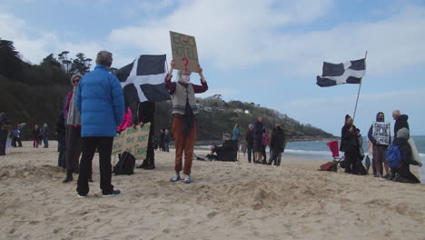 Flaggen-Wehen,-Als-Sich-Demonstranten-Am-Strand-Vor-Dem-Carbis-Bay-Hotel-In-St.-Ives,-Cornwall,-Versammeln