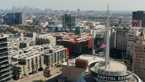 Aerial-view-over-the-Capital-Records-building,-in-Hollywood,-and-downtown-Los-Angeles,-California