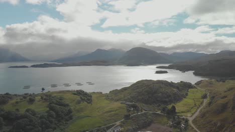 Aerial-drone-shot-of-beautiful-scottish-landscape-in-north-highlands-with-lake-bay-and-green-mountains-in-sunny-day-uk