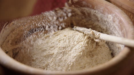 BAKING---Sprinkling-flour-on-the-batter,-sourdough-bread,-slow-motion-close-up