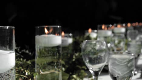 Gorgeous-head-table-flat-lay-of-white-floating-candles-in-crystal-vases-with-beautiful-floral-arrangements-surrounding-them-at-Strathmere-Wedding-and-Event-center-in-Ottawa,-Canada