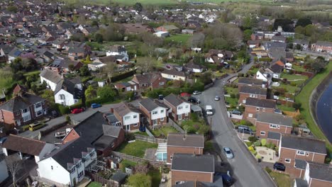 Aerial-drone-reveal-shot-moving-backwards-over-rural-countryside-houses,-England
