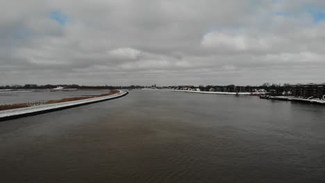 Wolkenlandschaft-über-Einem-Ruhigen-Kanal-Mit-Frachtschiffen,-Die-Mit-Intermodalen-Containern-Beladen-Sind,-Die-Den-Fluss-Noord-In-Den-Niederlanden-überqueren