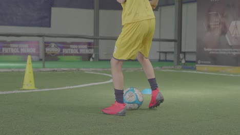 Junger-Mann-Trainiert-Fußball-Mit-Ball-Auf-Synthetischem-Fußballfeld
