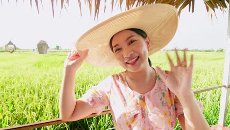 Asian-woman-making-video-call-showing-large-rice-production-field