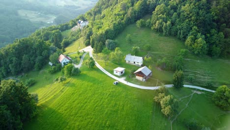 Ferienhäuser-Und-Kleine-Bauernhöfe-In-Hügeln,-Umgeben-Von-Grünen-Wiesen-Und-Wäldern