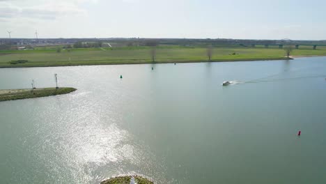 Aerial-view-of-small-speedboat-sailing-down-river-in-countryside