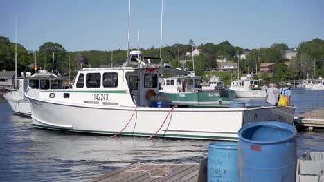 Commercial-lobster-fishermen-pull-up-their-boat-to-dock-and-unload-their-catch-of-the-day
