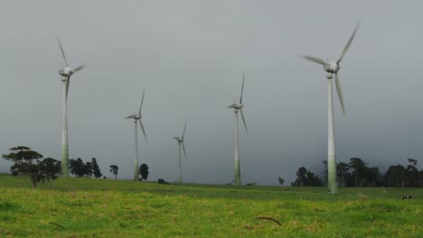 Wind-turbine-at-green-grassland-in-a-bad-overcast-moody-weather,-wide-static-shot