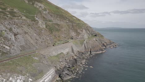 Train-On-The-Cliff-In-Bray-Town,-Wicklow,-Ireland---aerial-shot