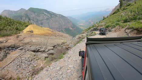 POV-from-rooftop-of-4WD-Jeep-vehicle-following-another-Jeep-on-Black-Bear-Pass-trail-along-Ingram-Creek-high-above-Telluride-Colorado