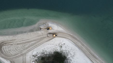 Blick-Von-Oben-Auf-Einen-Muldenkipper,-Der-Für-Ein-Erosionssanierungsprojekt-Sand-Entlang-Einer-Küstenlandzunge-Transportiert
