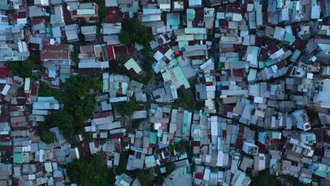 Saigon,-Ho-Chi-Minh-City,-Vietnam-top-down-shot-over-densely-populated-area-with-thousands-of-terrace-houses,-high-rise-buildings,-alleyways,-and-roads-with-moving-traffic
