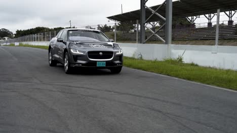 Auf-Der-Rückseite-Des-Jaguars-Fahre-Ich-Mit-Einem-Grauen-Elektroauto-Auf-Der-Rennstrecke