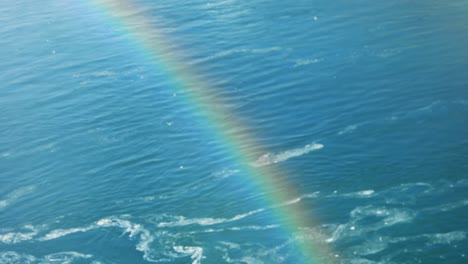 Close-up-of-rainbow-with-water-flowing-during-winter-in-background