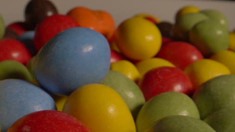 Macro-slider-showing-many-multi-colored-chocolate-balls-lighting-by-professional-light-in-studio