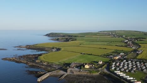 Green-coastal-Ireland,-field-patchwork,-campsite,-road-and-ocean-views