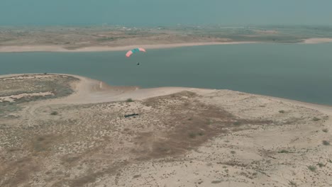 Vista-Aérea-Volando-Parapente-Motorizado-Sobrevolando-La-Costa-árida-Junto-Al-Lago-Salado