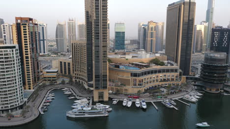 Luxurious-Yachts-Docked-Outside-The-Building-Of-Dubai-Marina-Mall-In-Dubai,-UAE