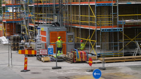 Hombres-Trabajando-Esperando-Que-El-Ascensor-Industrial-Baje-En-El-Sitio-De-Construcción-En-Gotemburgo,-Suecia